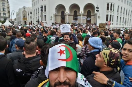 متظاهرون بالجزائر يلقون شرطيًا من أعلى السيارة بسبب إطلاقه الغاز (صورة)