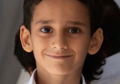 رغم إعادة تأهيله.. طفل يحمل الكتاب لا إراديا كحمله لسلاح الحوثي -صورة