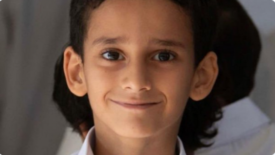 رغم إعادة تأهيله.. طفل يحمل الكتاب لا إراديا كحمله لسلاح الحوثي -صورة