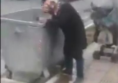 شاهد..سيدة إيرانية تبحث عن طعام في صندوق قمامة